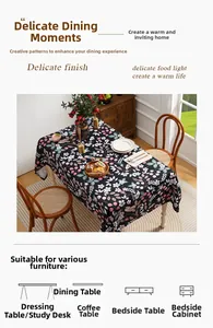 Detail of floral tablecloth featuring pink flowers and green leaves on a black base