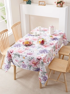 Détail d'une nappe imperméable avec motifs floraux roses et violets sur un fond blanc