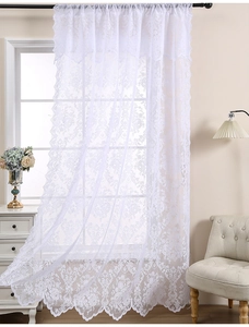 Détail du rideau en dentelle blanche vintage française avec motifs floraux et bords festonnés