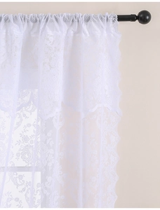 Gros plan rideau dentelle française blanche avec broderie florale et bords festonnés