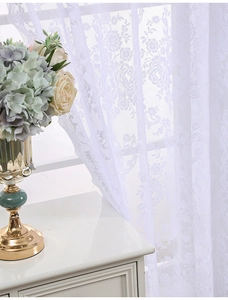 Gros plan du rideau en dentelle blanche semi-transparente avec motifs jacquard de roses