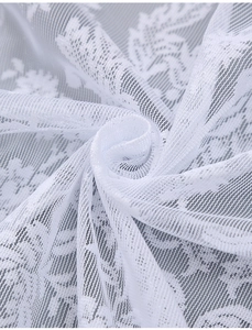 Vue rapprochée du tissu en dentelle blanche avec motifs de feuilles et maille fine
