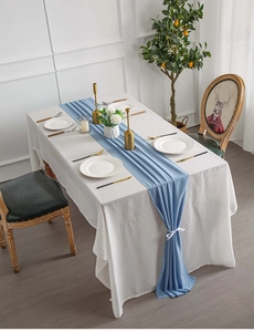 Detail of blue chiffon table runner with white ribbon on a minimalist dining table