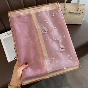 Détail d'une écharpe en soie rose avec broderie papillon 3D et perles blanches