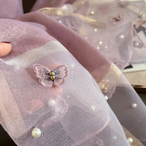 Détail d'une écharpe en soie violette avec broderie papillon et perles artificielles