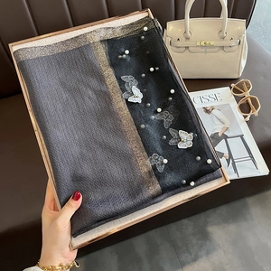Détail d'une écharpe en soie avec broderie papillon 3D, perles et rayures métalliques