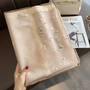 Détail du châle en soie champagne avec broderie papillon et décorations de perles blanches