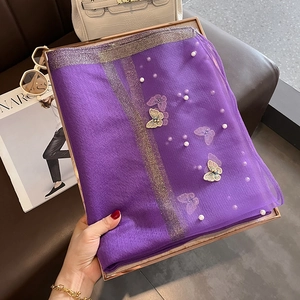 Détail d'une écharpe en soie violette avec broderie papillon et perles élégantes