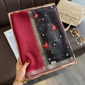 Détail de la broderie papillon rouge et des perles sur l'écharpe d'hiver chaude