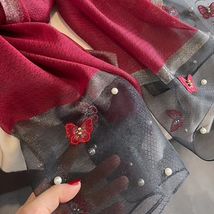 Broderie détaillée de papillon rouge et perles blanches sur tissu de foulard noir