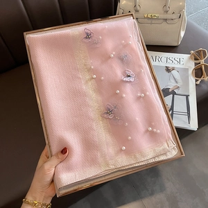 Détail d'une écharpe en soie rose avec broderie papillon et perles en coffret