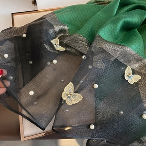 Vue détaillée d'une écharpe élégante avec broderie papillon et perles blanches
