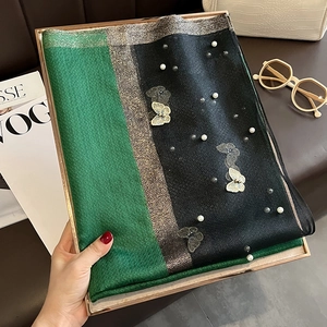 Détails de broderie papillon et perles blanches sur une écharpe en soie élégante