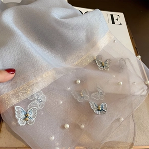 Détail de l'écharpe en soie avec broderie de papillon 3D et accents de perles blanches