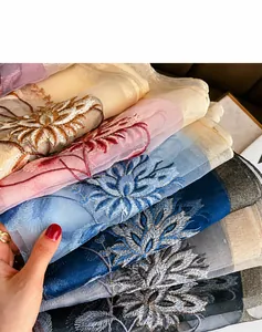 Vista de bordados florales sobre el tejido translúcido de seda y lana del chal