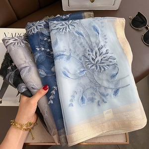 Détail de quatre écharpes en soie et laine avec d'élégants motifs floraux brodés