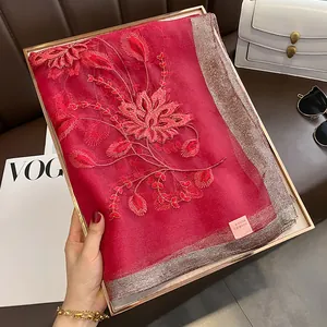 Détail d'un châle rouge en soie et laine avec bord argenté et broderie florale