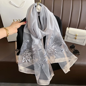 Broderie détaillée de fleurs bleu marine sur une écharpe en soie et laine bleu clair