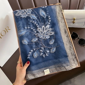 Détail d'un châle en soie et laine bleu marine avec broderie florale argentée