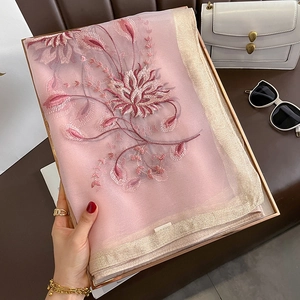 Détail d'une écharpe rose avec broderie florale 3D et ourlet doré scintillant