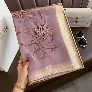 Détails de broderie florale sur une écharpe élégante en soie et laine de couleur mauve