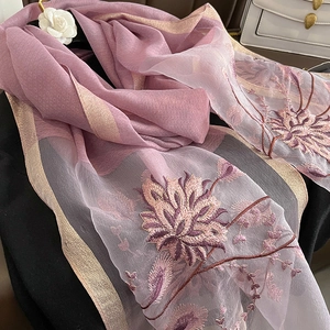 Broderie détaillée de motifs floraux roses sur une écharpe en soie violette aux bords d'or
