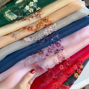Detailed view of colorful floral embroidery on sheer organza fabric scarves for women
