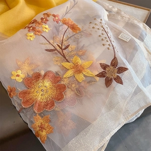 Detail of floral embroidery on off-white silk wool shawl with silver silk edge trim
