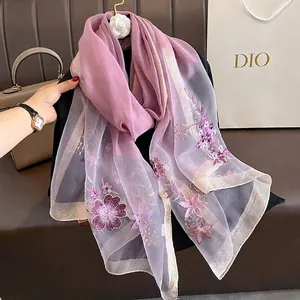 Detailed embroidery of purple floral patterns on sheer silk wool gradient shawl wrap