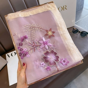 Detail of purple faux silk wool scarf featuring golden trims and floral embroidery