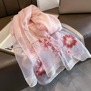 Detail of pink organza scarf with elegant floral embroidery and delicate gold thread outlines
