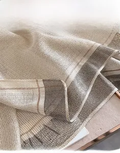 Macro shot of faux silk scarf with gold metallic threads and precise machine-hemmed edges