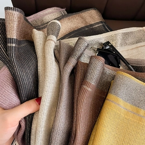 Detailed view of shimmering metallic silk-feel scarves in various elegant colors