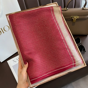 Detail of burgundy silk scarf with metallic gold stripes and luxury texture display