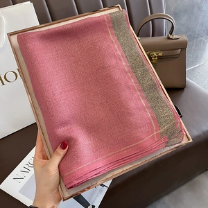 Detail of rose pink silk scarf with shimmering gold lurex edges and soft knit texture