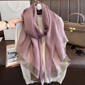 Detail of purple silk scarf with silver metallic thread texture on a knit top