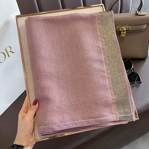 Detail of lavender silk scarf with gold metallic woven border and elegant accessories
