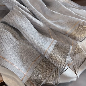 Close-up of pleated silk-like scarf featuring metallic gold thread and a silver grey texture