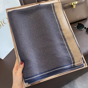 Close-up of luxury dark blue silk scarf with metallic gold stripes and woven texture