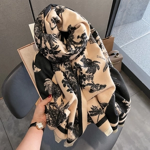 Détail d'un châle doux en cachemire avec imprimé palmier noir et bords à franges