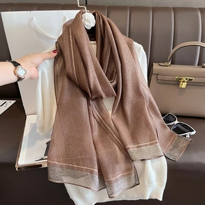 Detail of mocha brown silk scarf featuring metallic gold stripes and shimmering silver edges