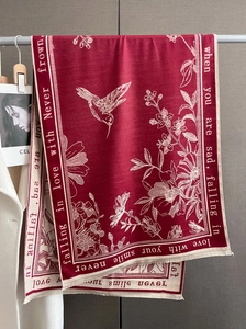 Detail of burgundy scarf with white hummingbird floral patterns and aesthetic text