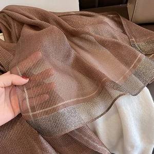 Detail showing brown silk scarf with metallic thread and transparent striped texture