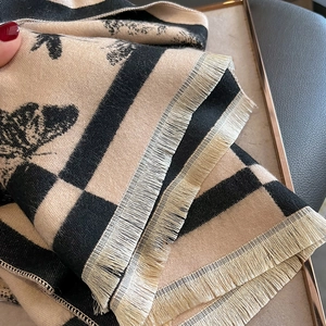 Détail d'une écharpe en cachemire doux montrant le tricot dense et les franges
