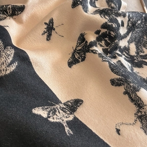 Vue macro détaillée du tissu tissé avec des motifs de papillons et de fleurs sur une écharpe