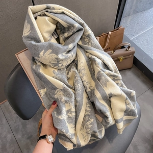 Détail de l'écharpe épaisse en imitation cachemire avec motif jacquard végétal gris et blanc
