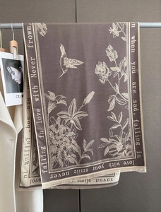 Detail of coffee brown scarf with hummingbird floral pattern and fringe tassels