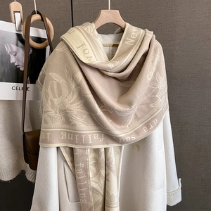 Elegant floral beige winter scarf shawl styled on a white coat with jacquard details