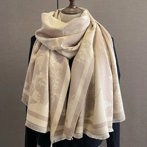 Détail d'une écharpe en cachemire beige jacquard avec franges et motifs tissés