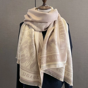 Detail of warm beige floral scarf with fringe and falling in love with woven text